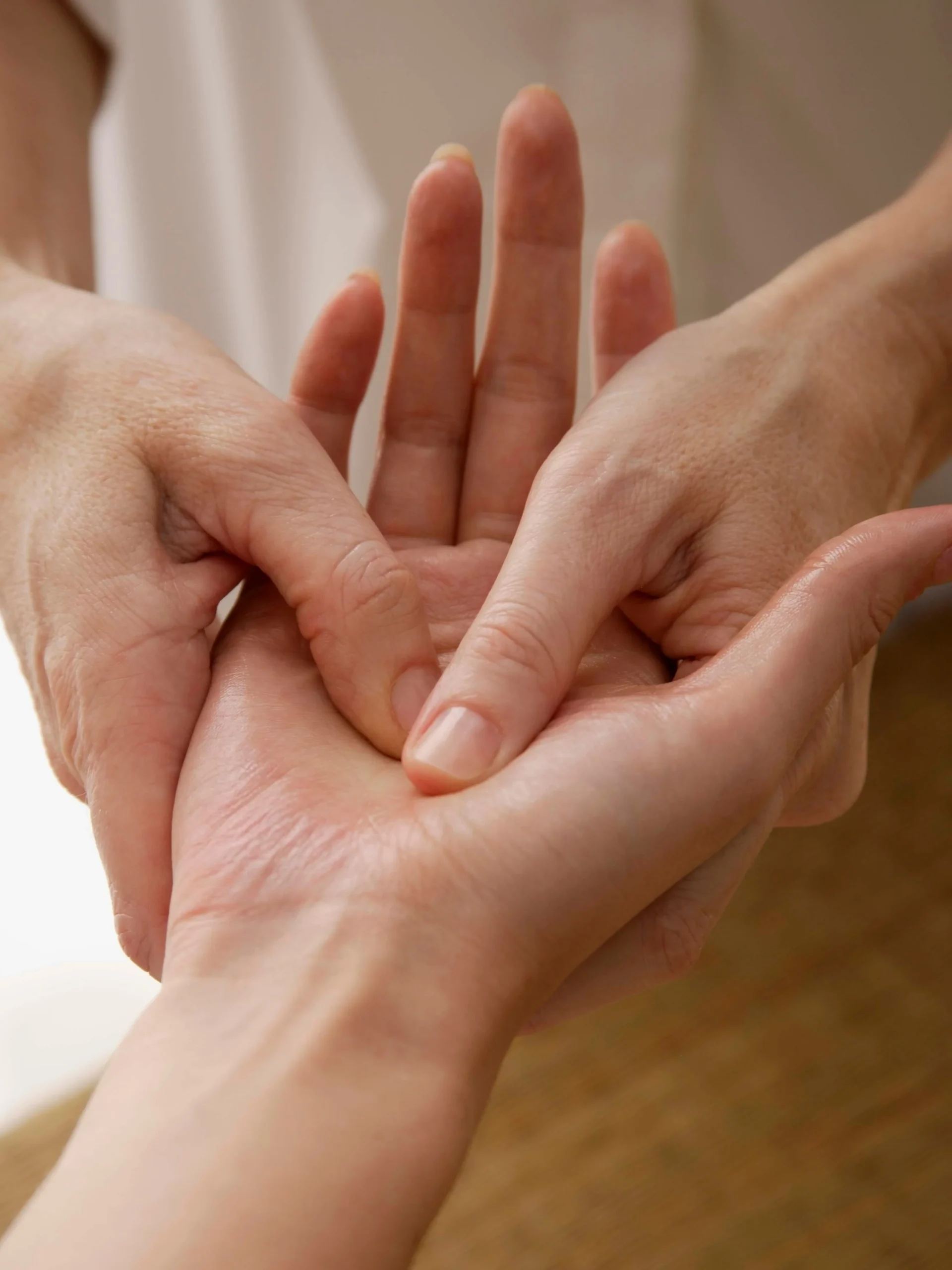 Close-up of a reflexologist treating a client’s hand