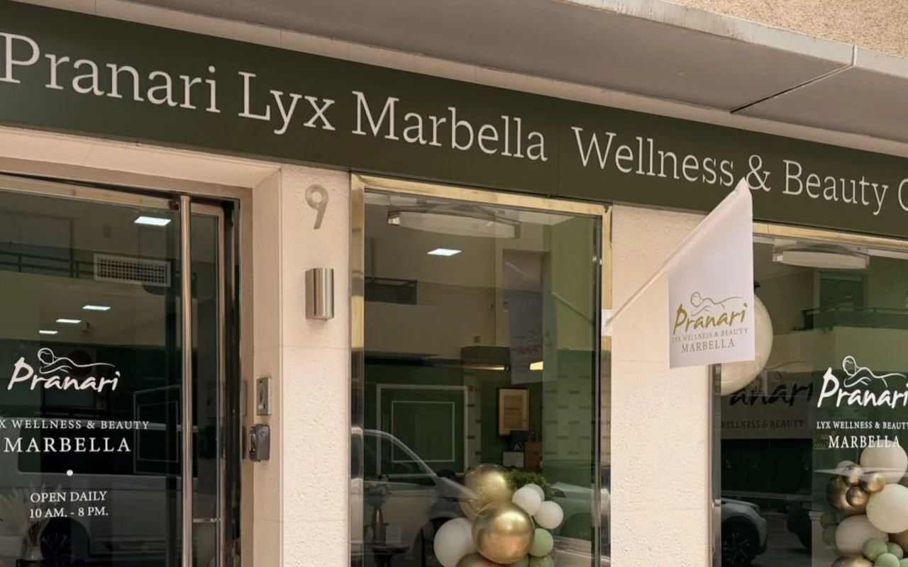 The Marbella premises of Anchan Massage, a green-fronted wellness and beauty studio with white and gold balloon displays beside the glass entrance.