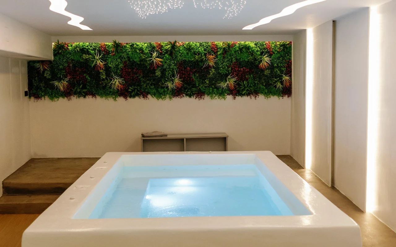 The hydrotherapy pool at Liana Spa Therapy on Naxos, lit softly from within, below a colourful preserved-plant living wall and a ceiling scattered with tiny star lights.